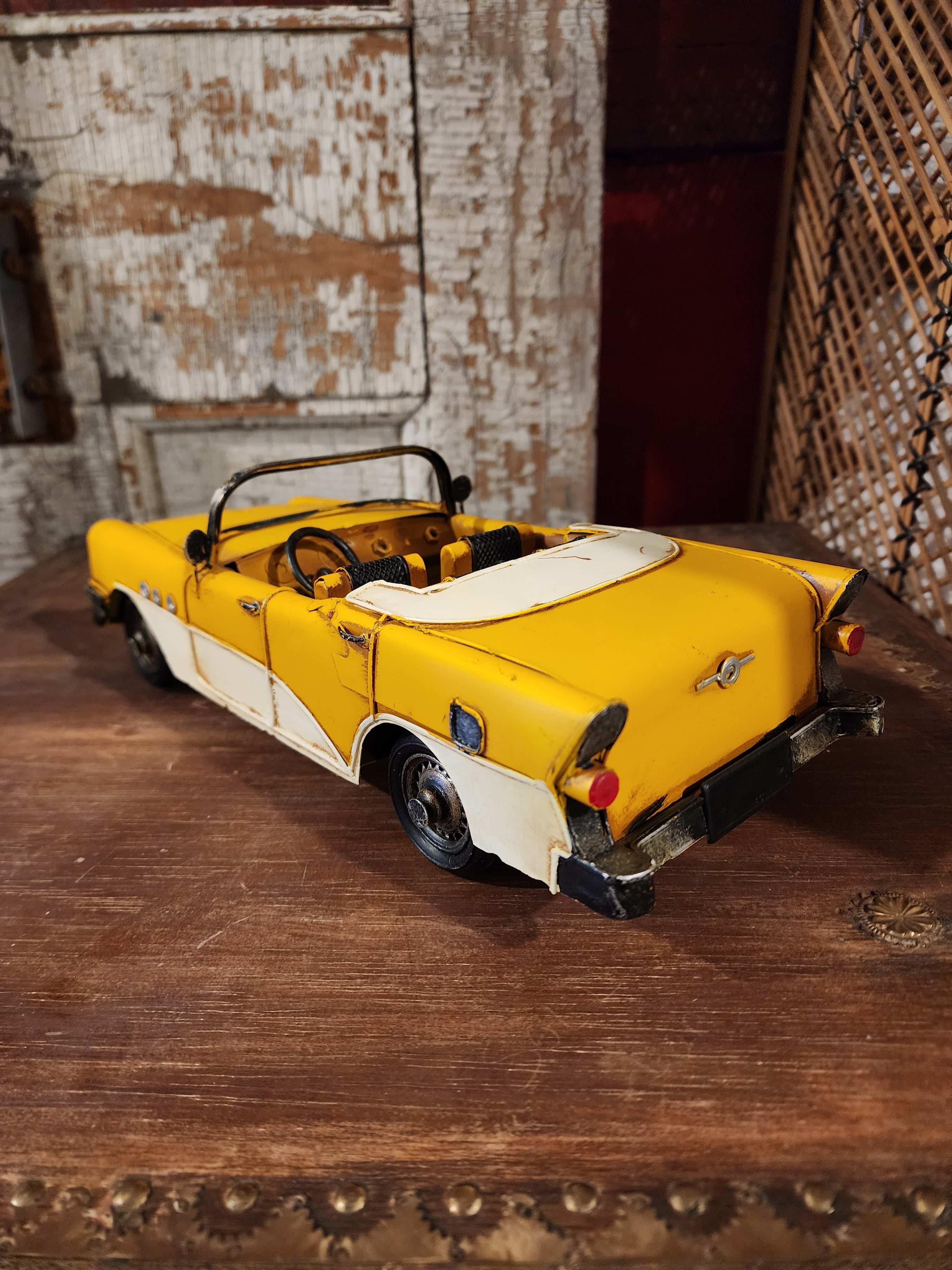 Side view of vintage metal automobile displayed on shelf