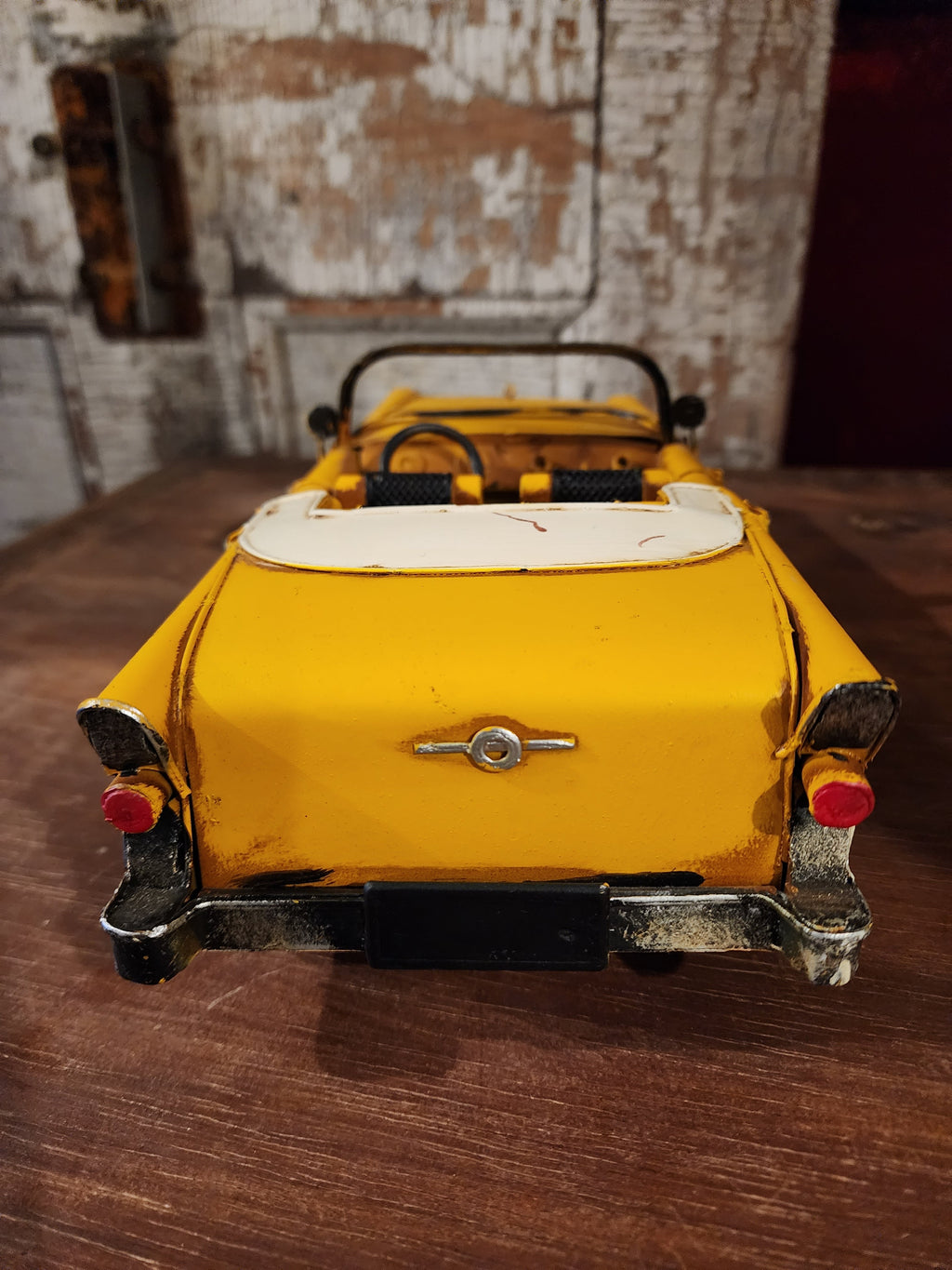 Antique-style tin automobile model with rustic finish and curved fenders