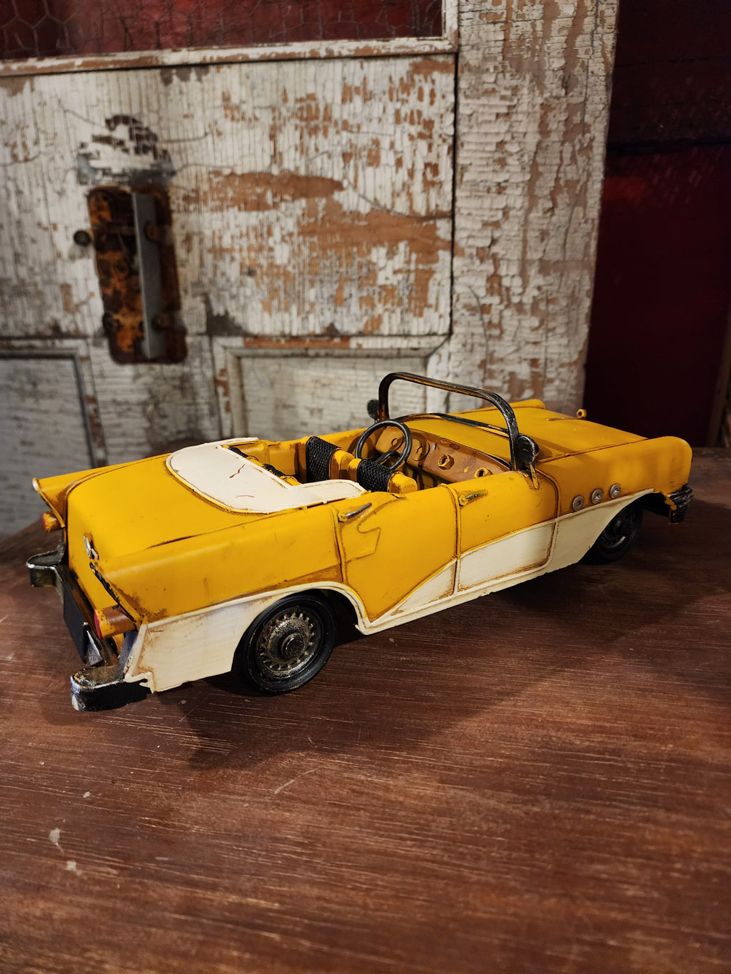 Side view of vintage metal automobile displayed on shelf