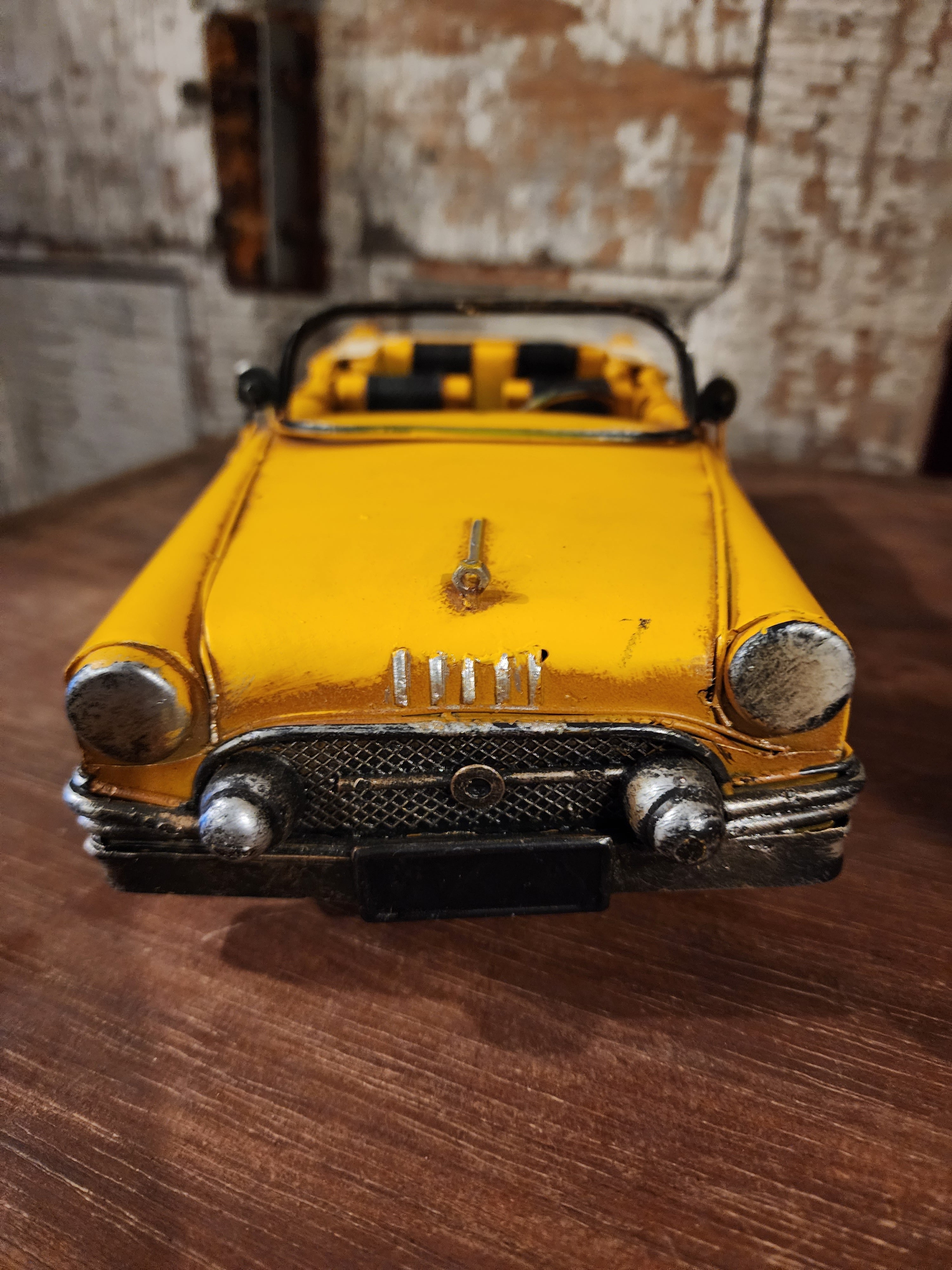 Side view of vintage metal automobile displayed on shelf