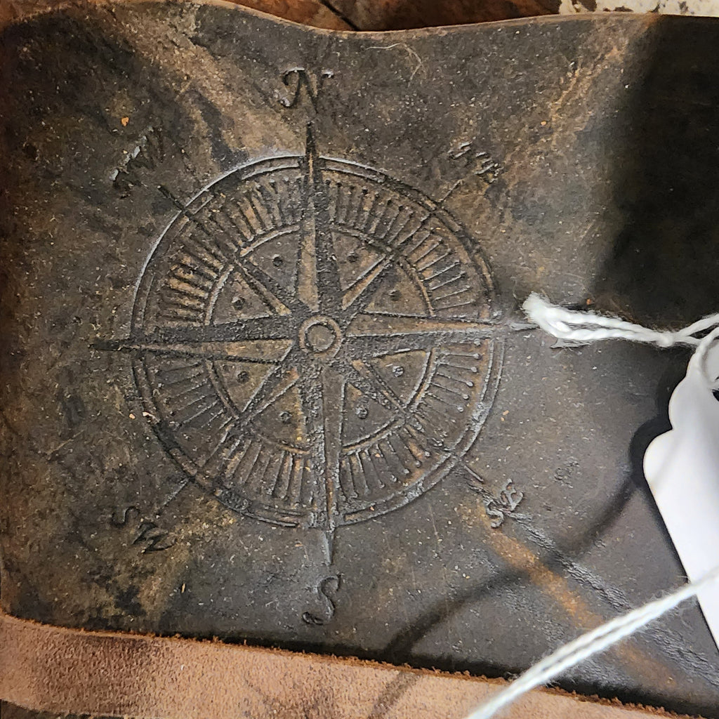 Distressed walnut leather journal closed beside books | The Olde 1840