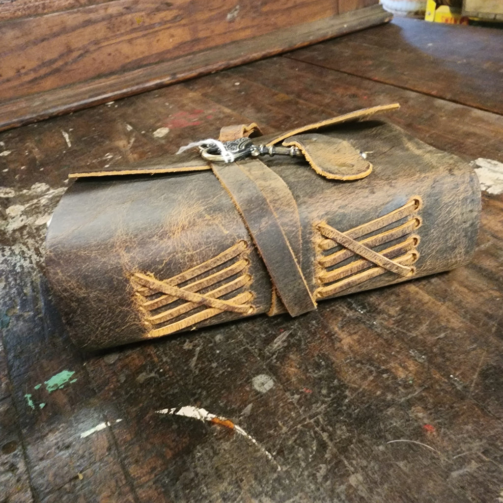 Open brown leather journal with blank pages